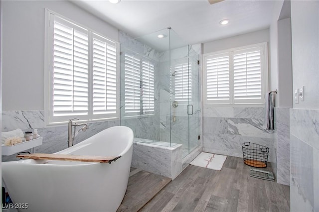 bathroom featuring hardwood / wood-style floors, tile walls, and independent shower and bath