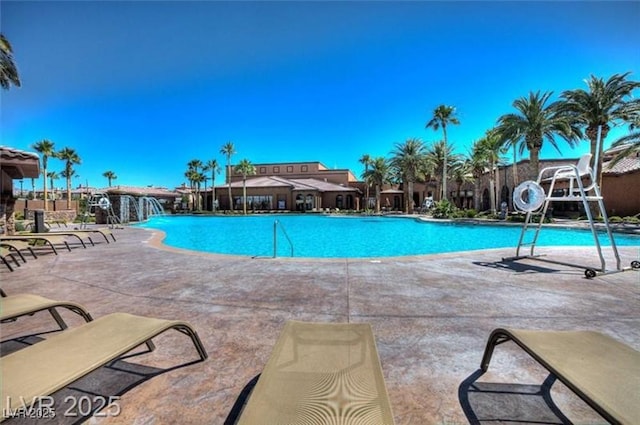 view of pool with a patio area, pool water feature, and a water slide