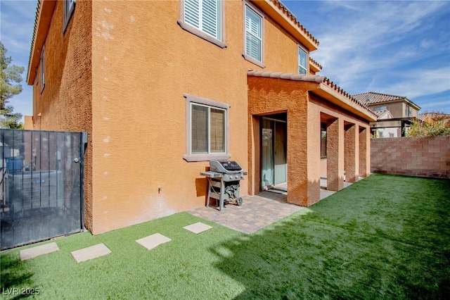 rear view of house featuring a yard and a patio