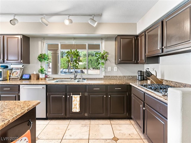 kitchen featuring stainless steel appliances, sink, dark brown cabinetry, and light tile patterned flooring