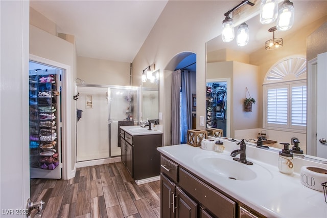 bathroom with hardwood / wood-style flooring, vanity, vaulted ceiling, and an enclosed shower