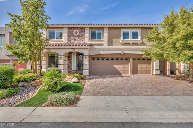 mediterranean / spanish home with stone siding, a tiled roof, decorative driveway, stucco siding, and an attached garage