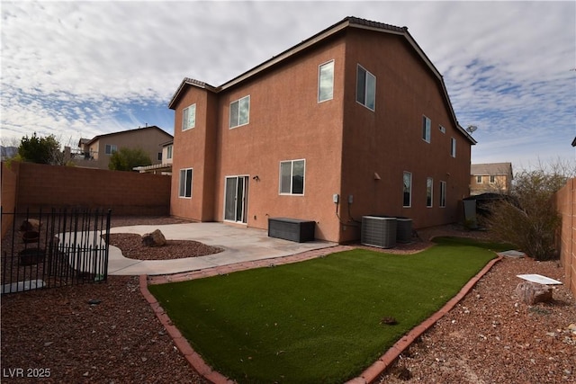 rear view of house featuring a lawn, a patio, central air condition unit, a fenced backyard, and stucco siding