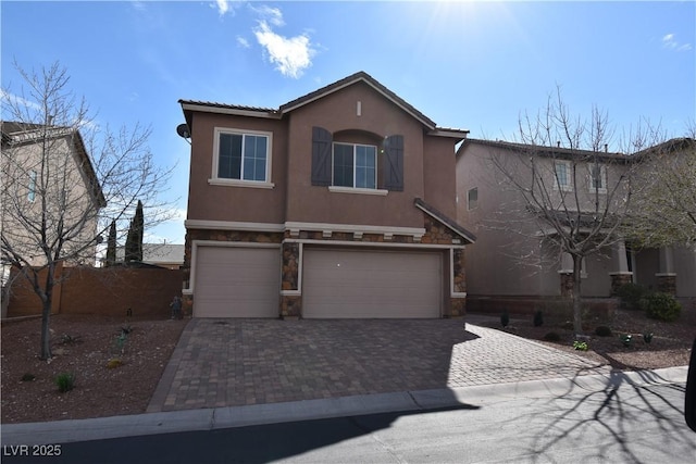 view of front facade featuring stucco siding, stone siding, decorative driveway, and a garage