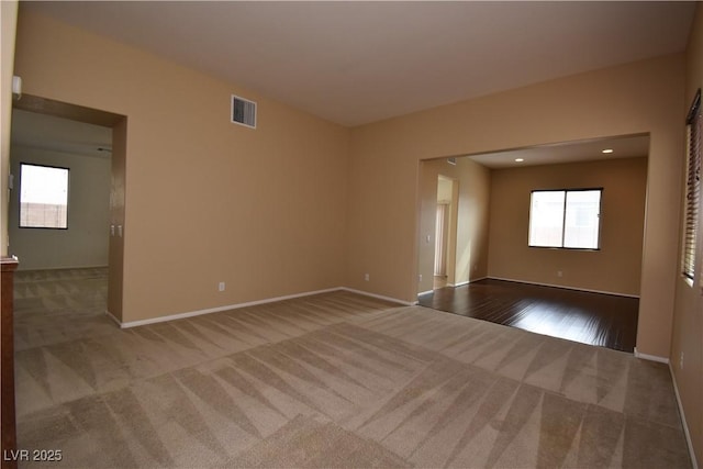 empty room with visible vents, light carpet, and a healthy amount of sunlight