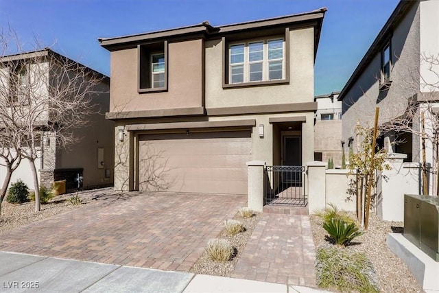 view of front of property featuring a garage, fence, decorative driveway, a gate, and stucco siding