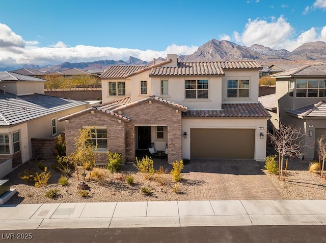 view of front of house featuring stucco siding, a mountain view, a garage, decorative driveway, and a tile roof