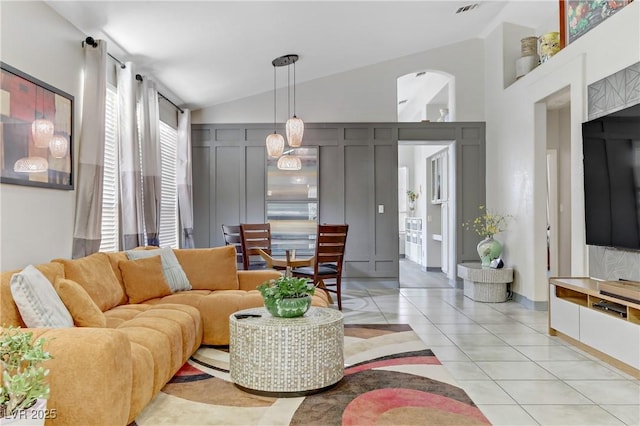 living area with lofted ceiling and light tile patterned flooring