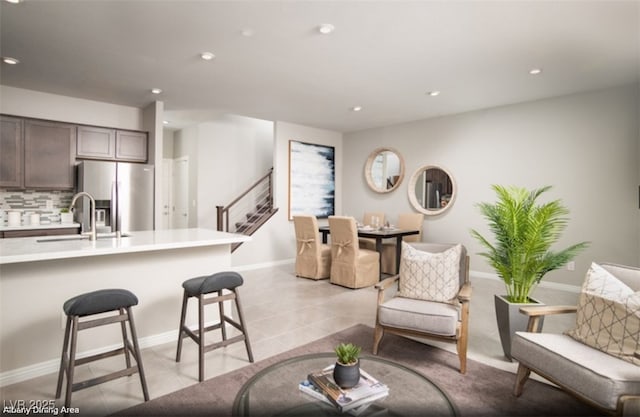 living area featuring recessed lighting, light tile patterned flooring, and stairs