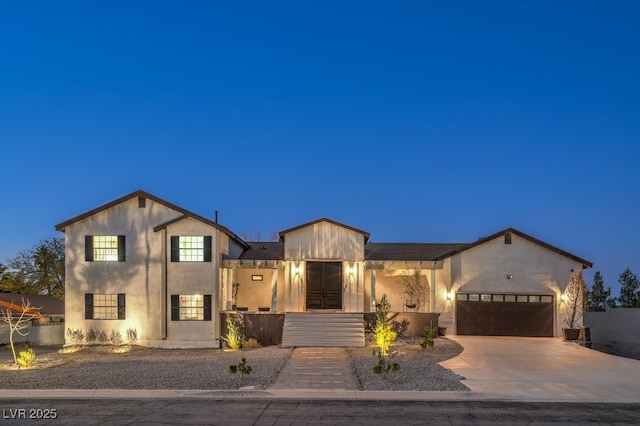 view of front of house featuring an attached garage, concrete driveway, and stucco siding