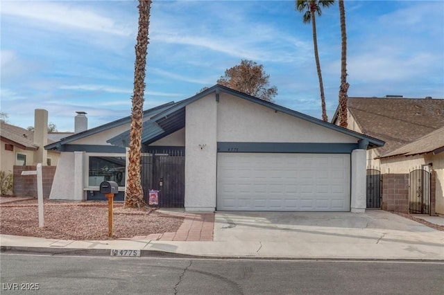 mid-century modern home with a garage, driveway, fence, and stucco siding