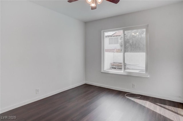 spare room with ceiling fan, baseboards, and dark wood-type flooring