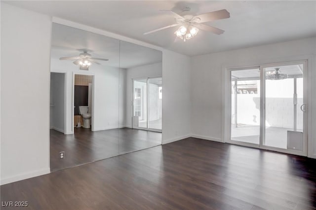 spare room with a ceiling fan, dark wood-style flooring, and baseboards