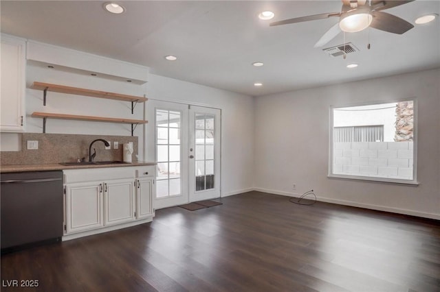 interior space featuring black dishwasher, visible vents, white cabinets, open shelves, and a sink