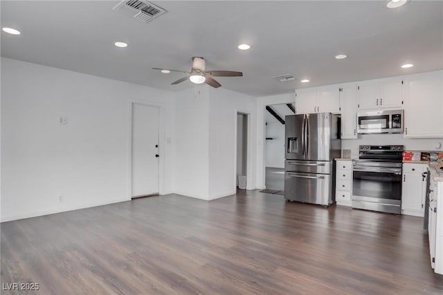 kitchen featuring dark wood-style flooring, visible vents, white cabinets, light countertops, and appliances with stainless steel finishes