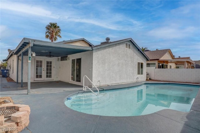 view of pool featuring a fenced in pool, ceiling fan, fence, french doors, and a patio area