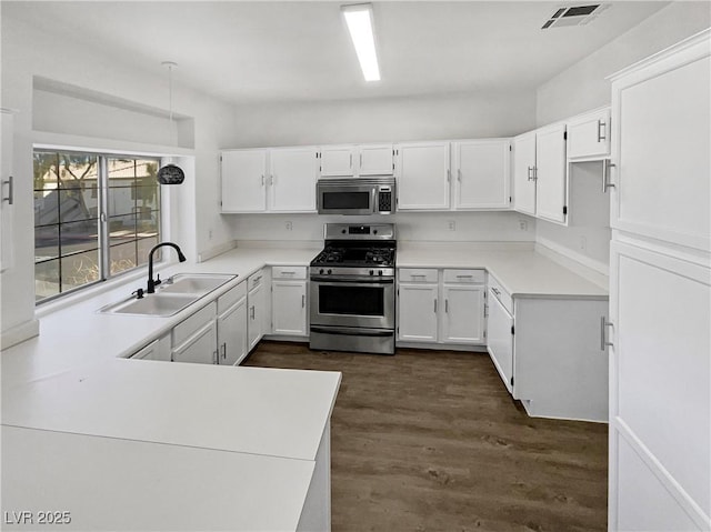 kitchen with light countertops, visible vents, appliances with stainless steel finishes, white cabinetry, and a sink