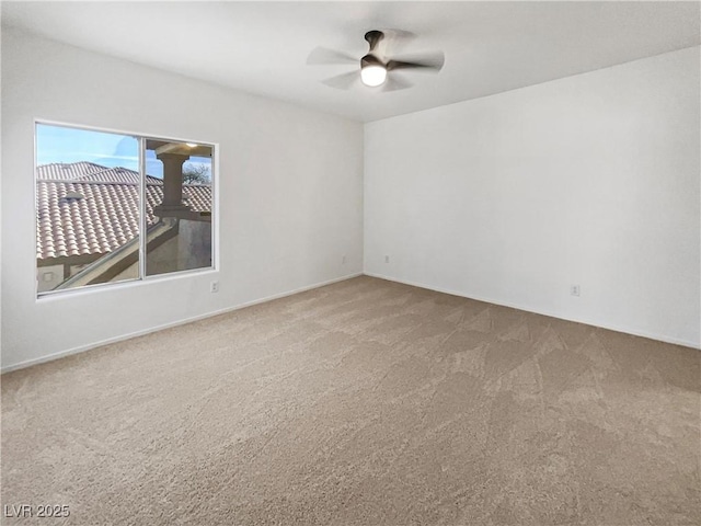 carpeted empty room with a ceiling fan