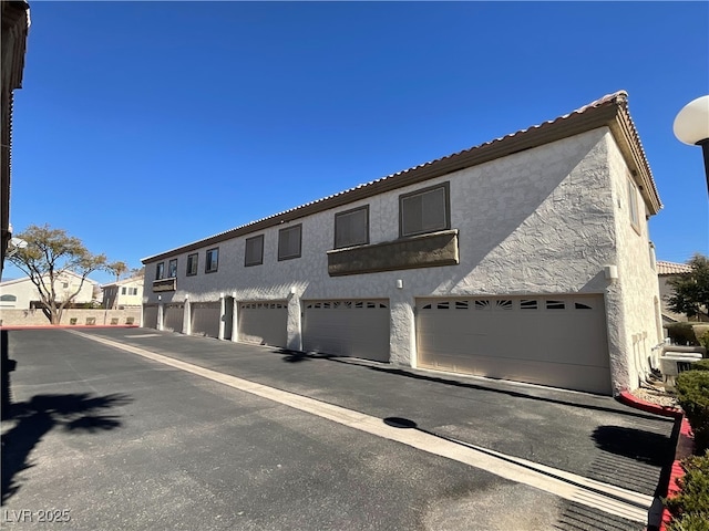 view of front of property featuring community garages, a residential view, and stucco siding