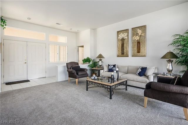 living area with light carpet, visible vents, and light tile patterned floors