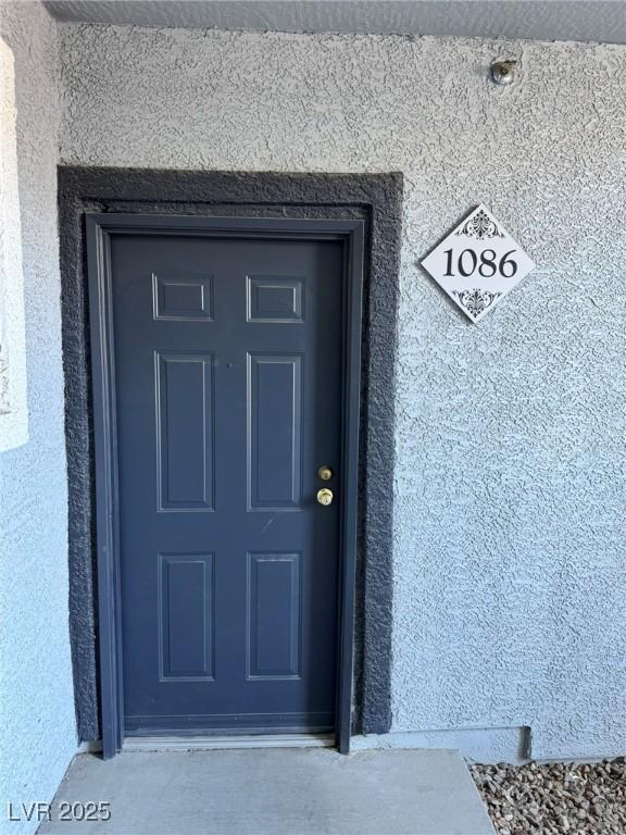 doorway to property featuring stucco siding