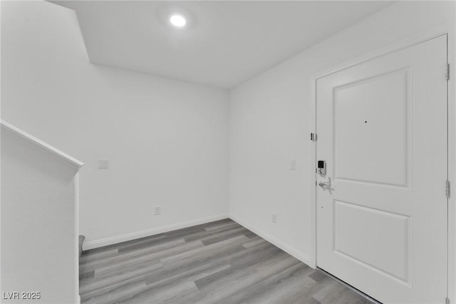 foyer with light wood-style flooring and baseboards