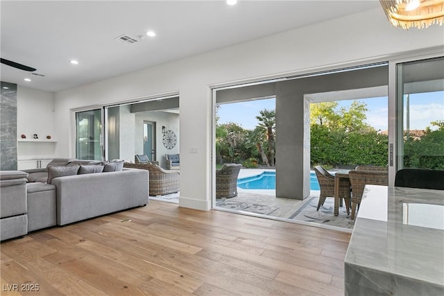 living room with a wealth of natural light, light wood-style flooring, and recessed lighting