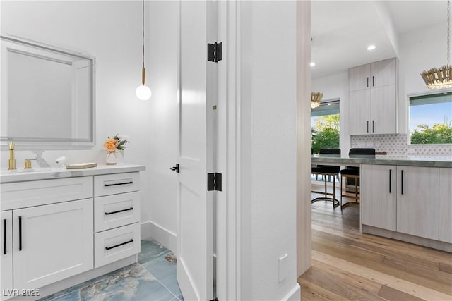 bathroom with recessed lighting, backsplash, vanity, and wood finished floors