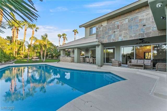 pool with ceiling fan, outdoor lounge area, and a patio