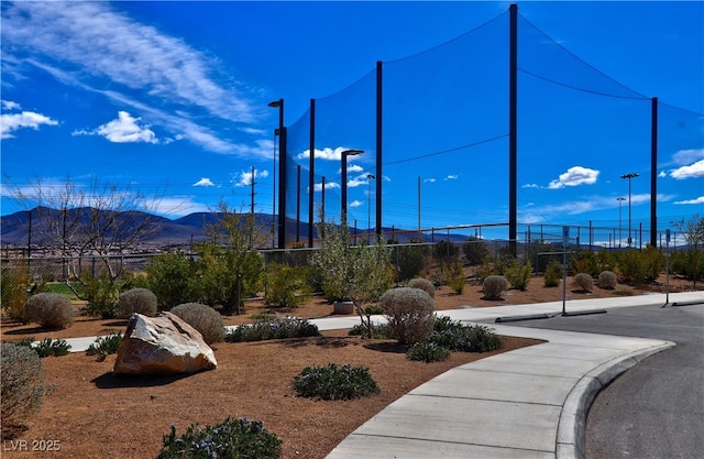 surrounding community with a mountain view and fence