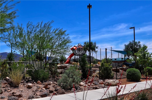 community play area featuring fence and a mountain view