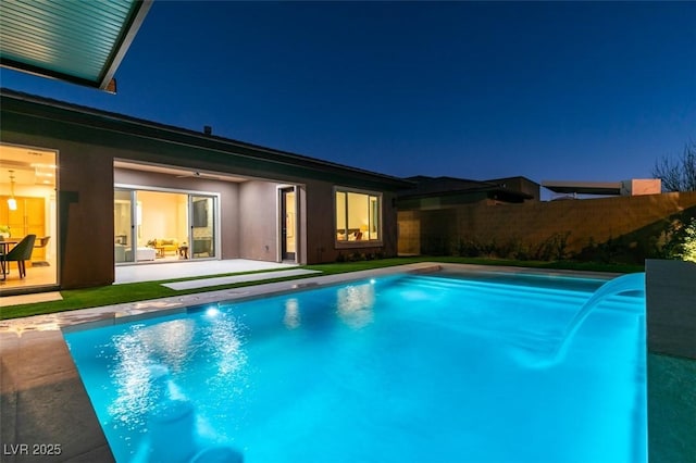 pool at twilight with a patio, fence, and a fenced in pool