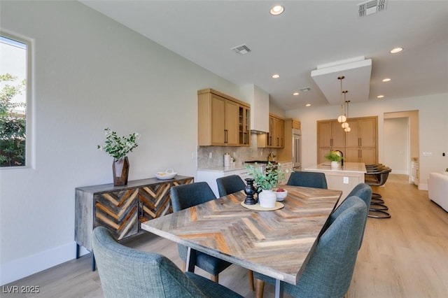 dining area with light wood-type flooring, visible vents, and recessed lighting