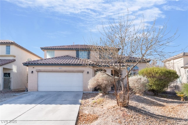 mediterranean / spanish home featuring a garage, concrete driveway, a tile roof, and stucco siding