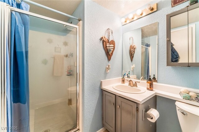 2245 Saint Paul Way, Las Vegas, NV 89104 - bathroom featuring a textured wall, a stall shower, vanity, and toilet