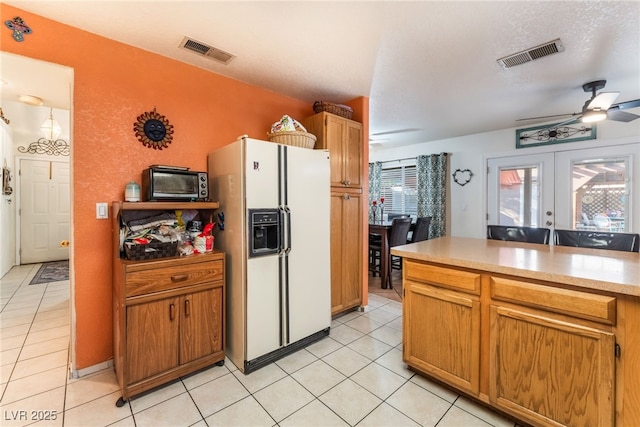 2245 Saint Paul Way, Las Vegas, NV 89104 - kitchen with brown cabinetry, white refrigerator with ice dispenser, light countertops, and visible vents