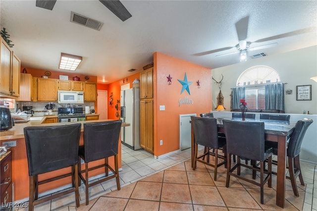 2245 Saint Paul Way, Las Vegas, NV 89104 - kitchen with white appliances, tasteful backsplash, light tile patterned floors, visible vents, and light countertops
