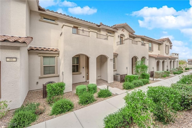 view of front of property with cooling unit, a tile roof, and stucco siding