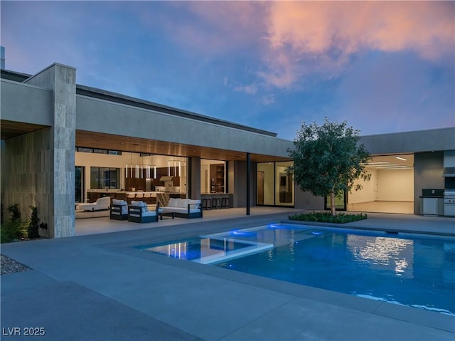 view of pool featuring area for grilling, a pool with connected hot tub, a patio area, and an outdoor living space