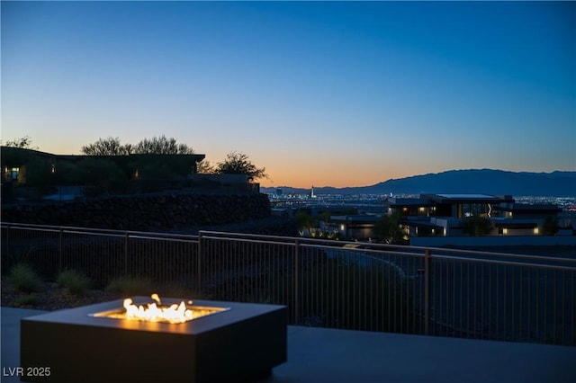 view of patio / terrace with an outdoor fire pit, a mountain view, and fence