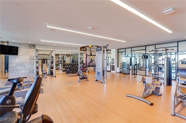gym with expansive windows and wood finished floors