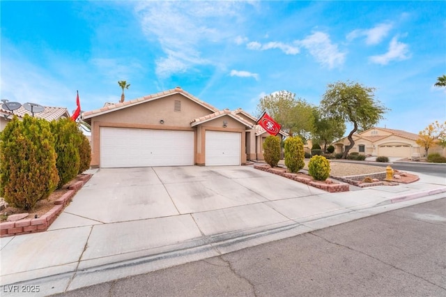 view of front of house with a garage, a tile roof, concrete driveway, a residential view, and stucco siding