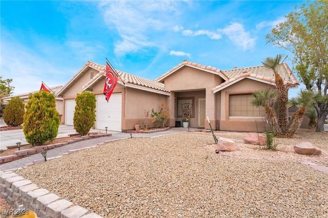 view of front of property with a tile roof, an attached garage, driveway, and stucco siding