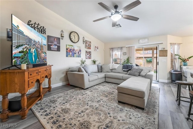 living room featuring lofted ceiling, wood finished floors, visible vents, and ceiling fan