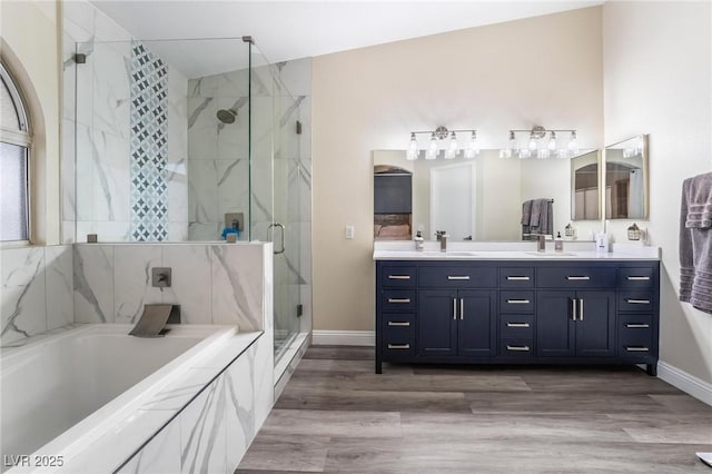 full bath featuring a garden tub, double vanity, a marble finish shower, and a sink