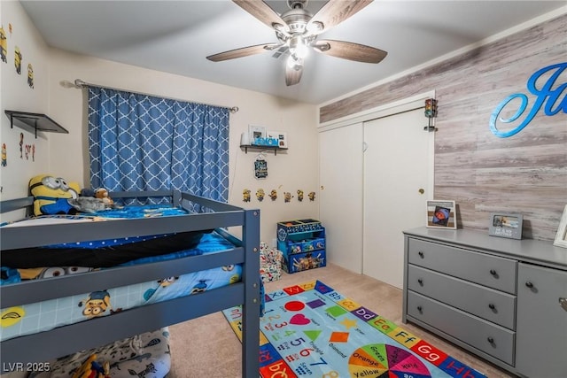 bedroom with a closet, wood walls, and ceiling fan