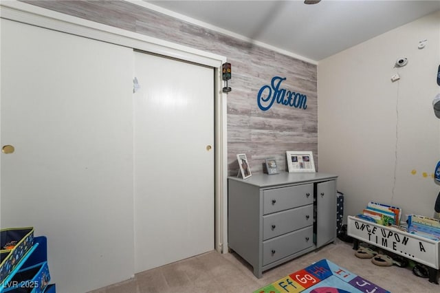 game room featuring light carpet and wooden walls