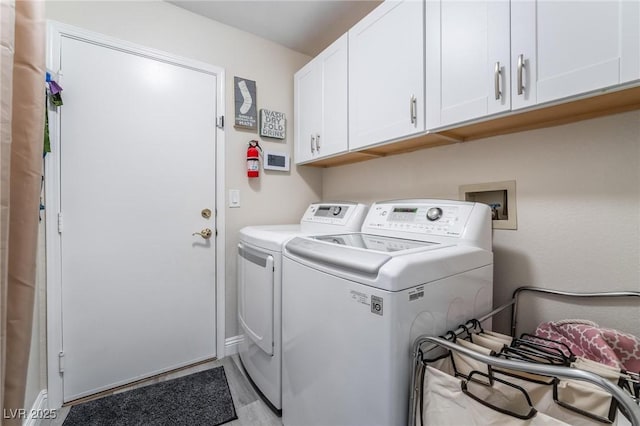 washroom with separate washer and dryer and cabinet space