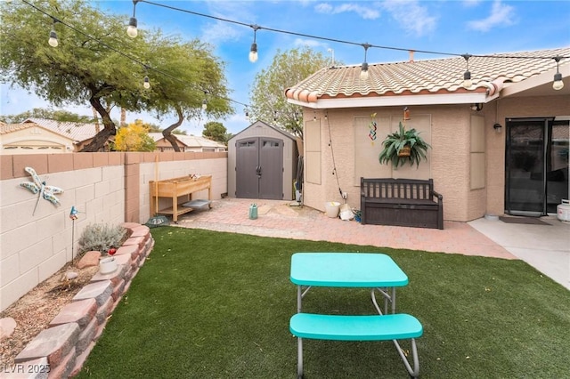 view of yard with an outdoor structure, fence, a shed, and a patio