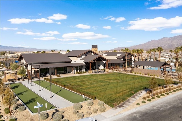 exterior space with a front lawn, a mountain view, and a residential view